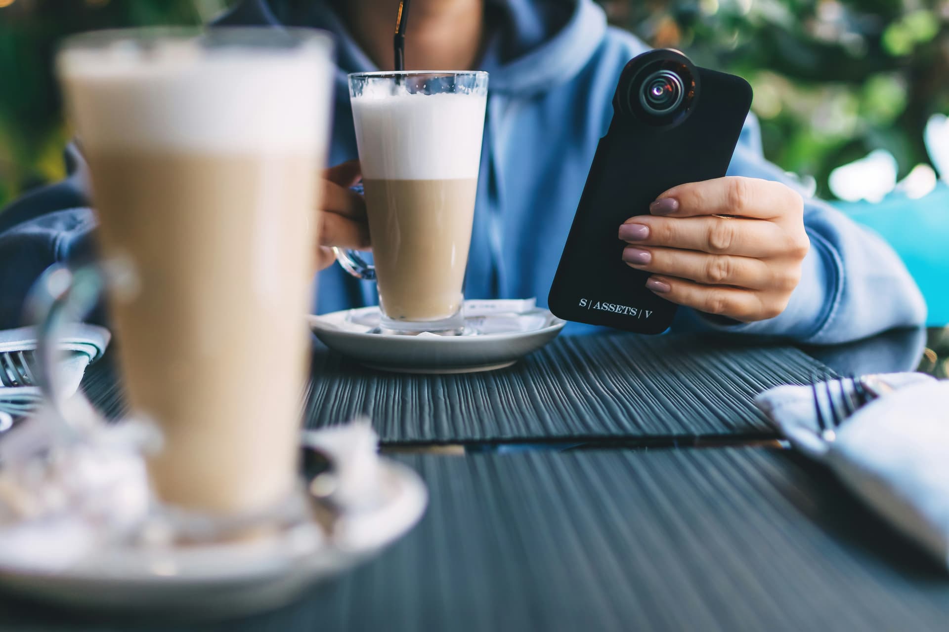 Mão segurando um smartphone moderno exibindo a interface otimizada do cardápio VamosPedir.online, demonstrando a facilidade de navegação para o cliente fazer pedidos.